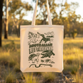 Tote bag with Australian reptile park design hanging in a natural setting